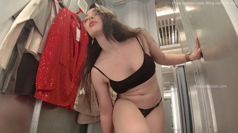 Trying on outfits in a fitting room with the curtains wide open